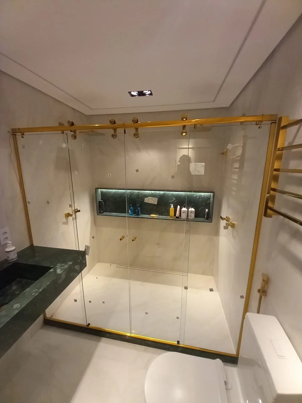 Box de vidro com perfil dourado instalado em banheiro